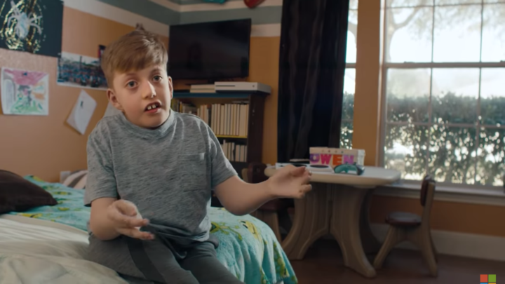 Image of Owen, a young boy, sitting on his bed, talking to the camera.